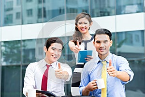 Asian businesspeople working outside with coffee