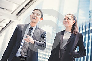 Asian businesswoman and businessman standing and talking outdoor