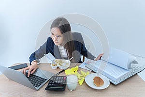 Asian businesswoman busy at work She ate while working because she was in a hurry to complete her goals