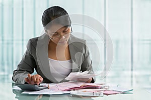 Asian businesswoman calculating bills