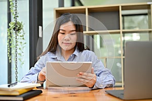 Asian businesswoman concentrating working her business task on digital tablet