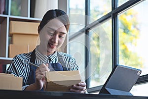 An Asian businesswoman enjoys his online SME business selling products, profiting from opening an online store, and taking orders