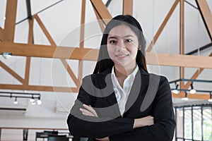 Asian businesswoman with folded hands smiling at camera. confide