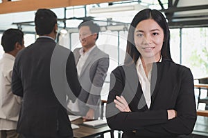 Asian businesswoman with folded hands smiling at camera. confide