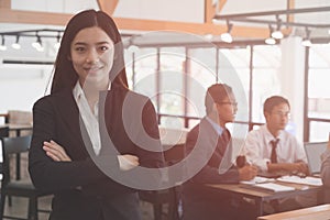 Asian businesswoman with folded hands smiling at camera. confide