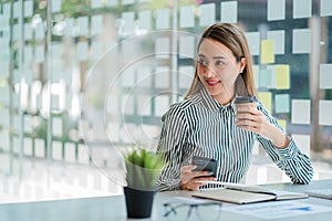 Asian businesswoman holding a cup of coffee working on investment projects and financial accounting planning strategies. Businessm