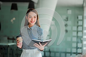 Asian businesswoman holding a cup of coffee working on investment projects and financial accounting planning strategies. Businessm