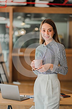 Asian businesswoman holding a cup of coffee working on investment projects and financial accounting planning strategies. Businessm