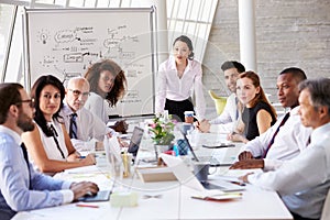 Asian Businesswoman Leading Meeting At Boardroom Table