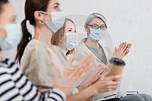 asian businesswoman in medical mask applauding