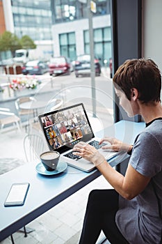 Asian businesswoman sitting at desk using laptop having video call