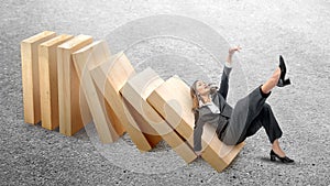 Asian businesswoman slipped on topple wooden block photo