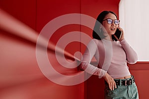 Asian Businesswoman Speaking by Smartphone in Red Space