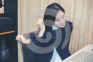 Asian businesswoman stretching after work hard in the office