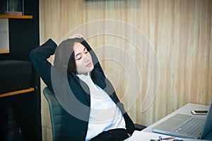 Asian businesswoman stretching after work hard in the office