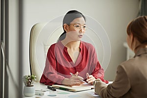 Asian Businesswoman Talking to Client in Office