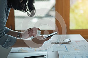 An Asian businesswoman uses a mobile phone to contact a customer to inform her of the company`s business partnership