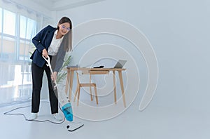 Asian businesswoman using a vacuum cleaner to clean Smile and be happy from your work