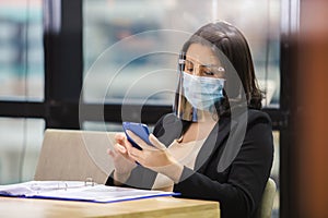 Asian businesswoman wear masks and face shield protect against airborne disease during outbreak of Covid-19 or coronavirus, relaxi