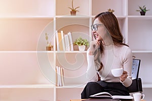 Asian businesswoman woman holding a cup of coffee relaxing in the office