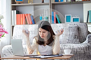 Asian businesswoman work on laptop while sitting at her working place at home. Business woman feeling busy, strain and tired work