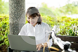 Asian businesswoman work in park