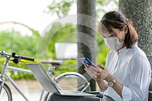 Asian businesswoman work in park