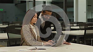 Asian businesswoman worker Korean female manager woman typing laptop online work task computer Arabian businessman