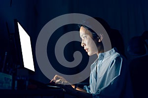 Asian businesswoman working on computer late at night in their office.