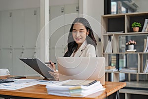 Asian businesswoman working for financial graphs showing results about their investments, planning successful business