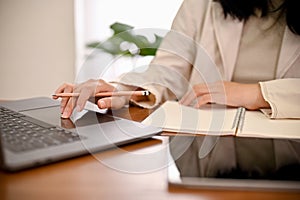 Asian businesswoman working at her office desk, using laptop computer. cropped shot