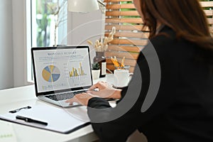 Asian businesswoman working with laptop computer and financial document at her workplace