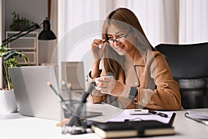 Asian businesswoman working with laptop computer and financial document at her workplace