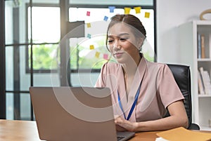 Asian businesswoman working on laptop in office. Successful Asian businesspeople working on computer while sitting at desk