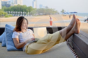Asian businesswoman working online at the beach. Freelancer using technology for work everywhere. New normal lifestyle