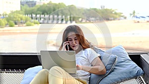 Asian businesswoman working online at the beach. Freelancer using technology for work everywhere. New normal lifestyle after Covid