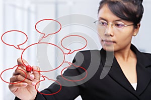 Asian businesswoman writing on glass board.