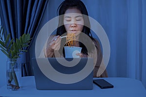 Asian businesswomen eating noodles late night stay up to work, busy and hungry during working