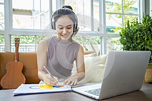 Asian businesswomen are using notebook computers and wear headphones for online meetings and working from home