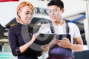 Asian Car mechanic and manager assigning tasks photo