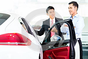 Asian Car Salesman selling auto