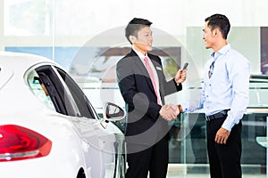 Asian Car Salesman selling auto photo