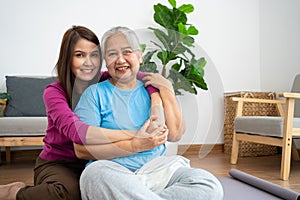 Asian careful caregiver or nurse taking care of the patient in a home.  Concept of happy retirement with care from a caregiver and