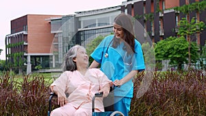 Asian careful caregiver or nurse taking care of the patient in a wheelchair.  Concept of happy retirement with care from a