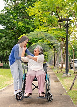 Asian careful caregiver or nurse taking care of the patient in a wheelchair. Concept of happy retirement with care from a