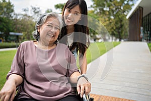 Asian careful caregiver or nurse taking care of the patient in a wheelchair. Concept of happy retirement with care from a