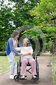 Asian careful caregiver or nurse taking care of the patient in a wheelchair. Concept of happy retirement with care from a