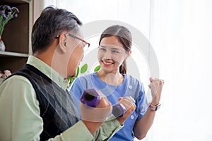 Asian caregiver woman or nurse training senior man lifting dumbbell for arm exercise while therapy and rehabilitation.