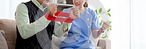 Asian caregiver woman or nurse training senior man stretch arm for exercise while therapy.