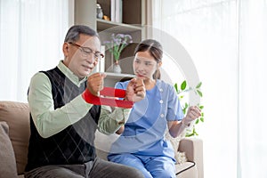 Asian caregiver woman or nurse training senior man stretch arm for exercise while therapy and rehabilitation.